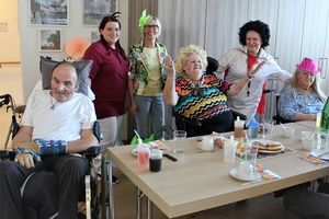 Gruppenfoto mit Bewohnern und Pflegepersonal bei einer festlichen Veranstaltung im Altenheim.