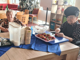 Drei Frauen bereiten gemeinsam Essen in einer Küche vor.