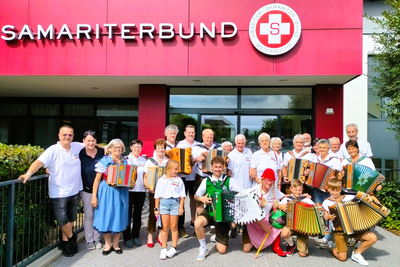 Gruppe von Musikern mit Akkorden vor dem Samariterbund-Gebäude.