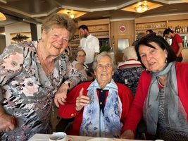 Drei Frauen lächeln glücklich zusammen in einem Restaurant.