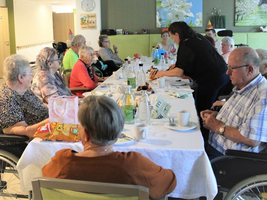 Ältere Menschen sitzen zusammen an einem Tisch und genießen gemeinsam ein Essen.