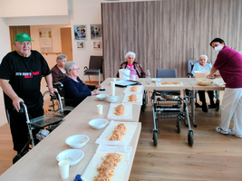 Gruppenaktivität mit älteren Menschen, die gemeinsam essen und sich unterhalten.