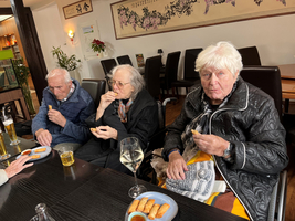 Drei ältere Menschen genießen Snacks in einem Restaurant.