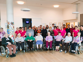 Gruppenfoto von Senioren und Betreuern in einem Gemeinschaftsraum.