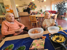 Drei ältere Frauen kochen gemeinsam in einer gemütlichen Küche.