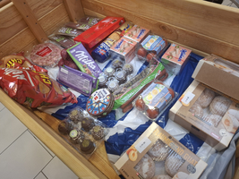 Eine Sammlung verschiedener Snacks und Süßigkeiten in einer Holzkiste.