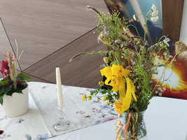 Ein bunter Blumenstrauß in einer Vase steht auf einem Tisch.