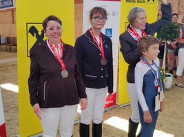 Drei Siegerinnen mit Medaillen stehen stolz auf dem Podium.