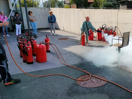Praxisübung zur Brandbekämpfung mit Feuerlöschern auf einem Außenplatz.
