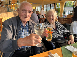 Ein älteres Paar prostet mit Gläsern in einem Restaurant.
