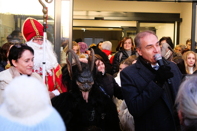 Krampus, Nikolaus und Gänste im Eingangsbereich. Redner hält Mikrofon