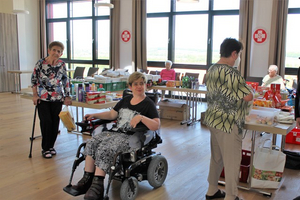 Drei Frauen in einem Raum mit Tischen voller Lebensmittel und Getränken.