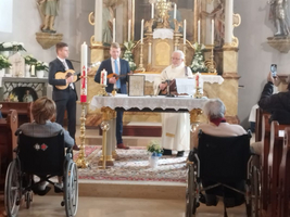 Zwei Männer spielen Ukulele während einer religiösen Zeremonie in einer Kirche.