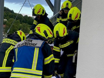 Feuerwehrleute tragen eine Person die Treppe hinunter.