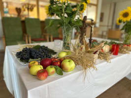 Ein Tisch dekoriert mit frischem Obst, Blumen und Ernteelementen.