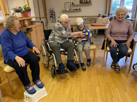 Vier ältere Frauen sitzen zusammen und spielen mit einem Ball.