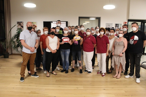 Eine Gruppe von Menschen trägt Masken und hält Preise in den Händen.