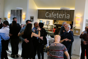 Tanzende Menschen in einer Cafeteria, fröhliche Stimmung und gesellige Atmosphäre.
