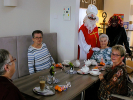 Eine Gruppe älterer Frauen feiert mit Nikoläusen bei einer Teetasse.