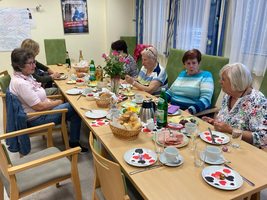 Eine Gruppe von Frauen sitzt zusammen und genießt ein gemeinsames Frühstück.