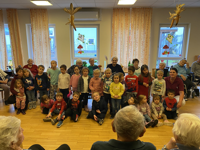 Kinder und Senioren stehen gemeinsam in einem Raum, um eine Feier zu genießen.