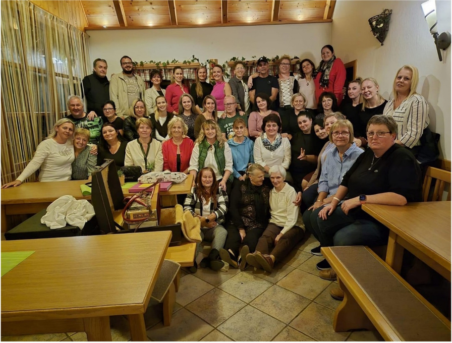 Eine große Gruppe von Menschen posiert lächelnd in einem Restaurant.