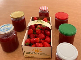 Erdbeeren und Marmeladengläser auf einem Tisch in einer Einrichtung für Senioren.