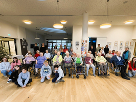 Gruppe von Senioren und Jugendlichen in einem Gemeinschaftsraum.