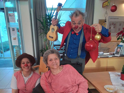 Drei Clowns, die Freude verbreiten, umgeben von einer fröhlichen Atmosphäre.