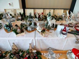 Weihnachtliche Dekorationen und Figuren auf einem Tisch mit Preisen.