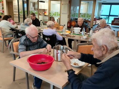 Senioren bei einer Aktivität, bei der sie Gegenstände sortieren und teilen.