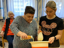 Zwei Frauen bereiten gemeinsam eine Mischung in einer Schüssel vor.