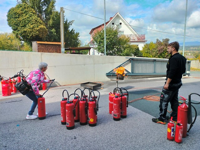 Eine Frau übt den Einsatz eines Feuerlöschers bei einem Brandschutztraining.