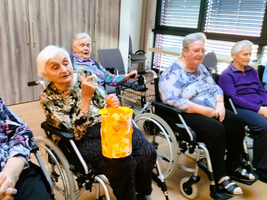 Eine Gruppe älterer Frauen sitzt im Raum, einige in Rollstühlen.
