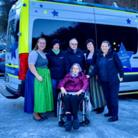 Irmgard mit Team und Familie vor Auto