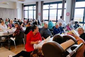 Senioren versammeln sich in einem hellen Speisesaal bei einer gemeinsamen Veranstaltung.