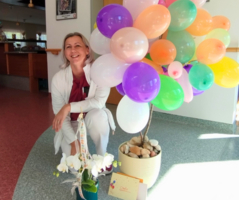 Mitarbeiterin mit Luftballons.