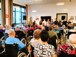 Eine Gruppe von Jugendlichen führt ein Weihnachtskonzert für Senioren auf.