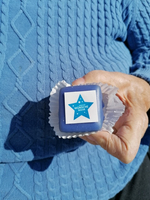 Eine Hand hält ein blaues Gebäck mit einem weißen Stern und der Aufschrift „Wünsche wahr“.