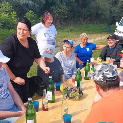 Eine Gruppe von Menschen sitzt an einem Tisch und genießt Getränke und Snacks.