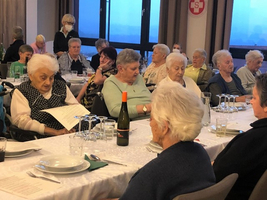 Eine Gruppe älterer Frauen sitzt an einem gedeckten Tisch in einem Restaurant.