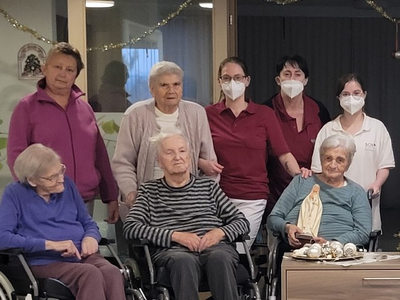 Gruppenfoto von Senioren und Betreuern in einem Pflegeheim.