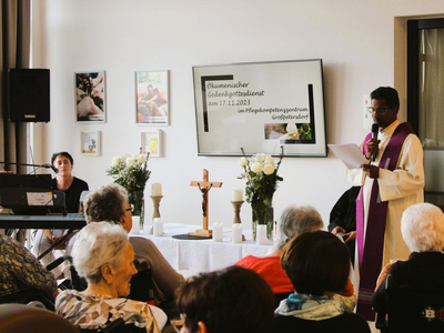 Ökumenischer Gottesdienst mit Musik und Ansprache, umgeben von Seniorinnen und Senioren.