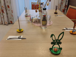 Ein festlich dekorierter Tisch mit Hasenfiguren und Ostereiern.
