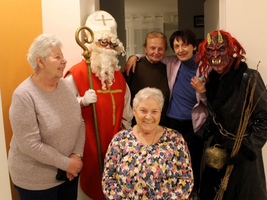 Eine Gruppe von sechs Personen, darunter eine Frau in traditioneller Nikolauskostüm.