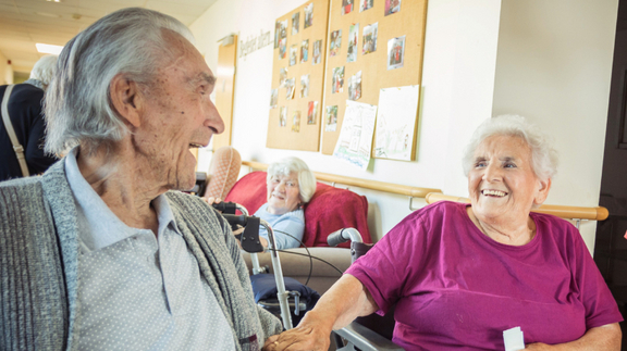 Im Pflegekompetenzzentrum: Älteres Ehepaar lacht sich fröhlich an