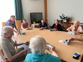 Senioren sitzen an einem Tisch und interagieren bei gemeinsamen Aktivitäten.