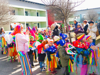 Bunte Kinder in Kostümen nehmen an einem Karnevalsumzug teil.