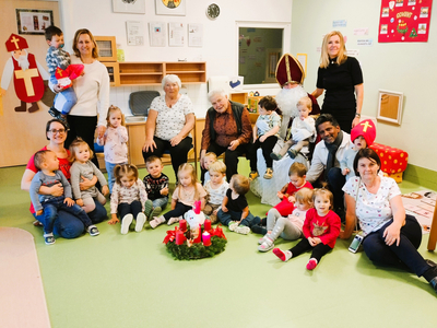 Gruppenszenen mit Kindern, Betreuern und Senioren in einem Spielraum.