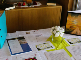 Tisch mit Materialien, Blumen und einer Botschaft über persönliche Wege im Leben.